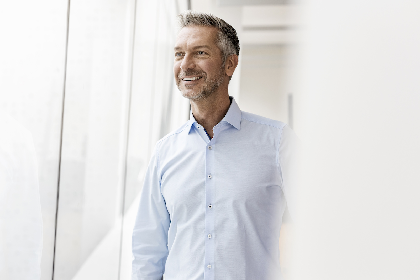 Unkonventionelles Business-Styling männliche Führungskraft im Büro am Fenster