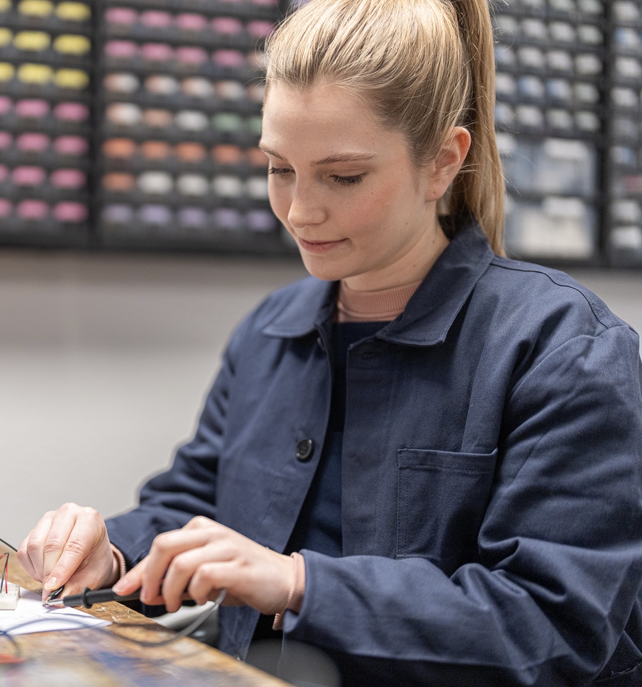 Biild von junger Frau in Arbeitskleidung und Pferdeschwanz